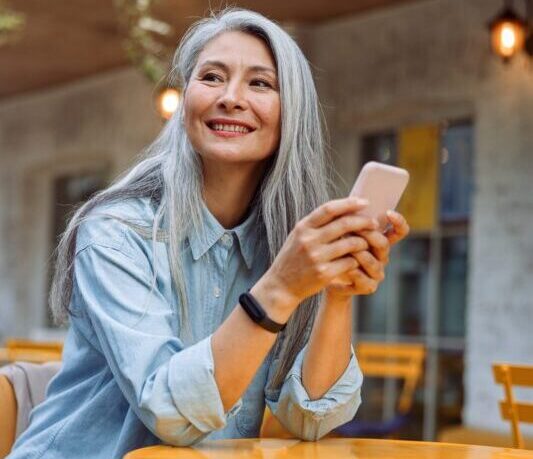 pretty-senior-asian-woman-holds-cellphone-at-small-2022-01-18-23-52-22-utc